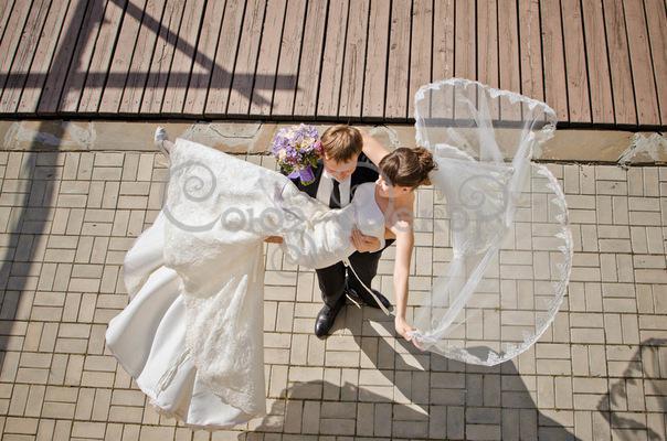 Жених в свадебном костюме с невестой на руках